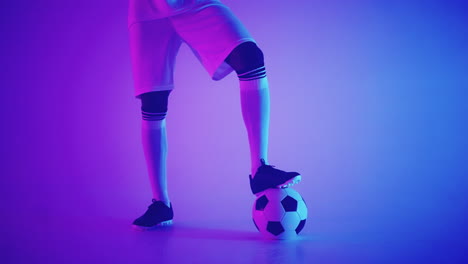 Close---up-of-a-soccer-ball-at-the-feet-of-a-football-player-in-the-studio-in-slow-motion-.-Professional-football-player-with-a-ball-in-the-studio